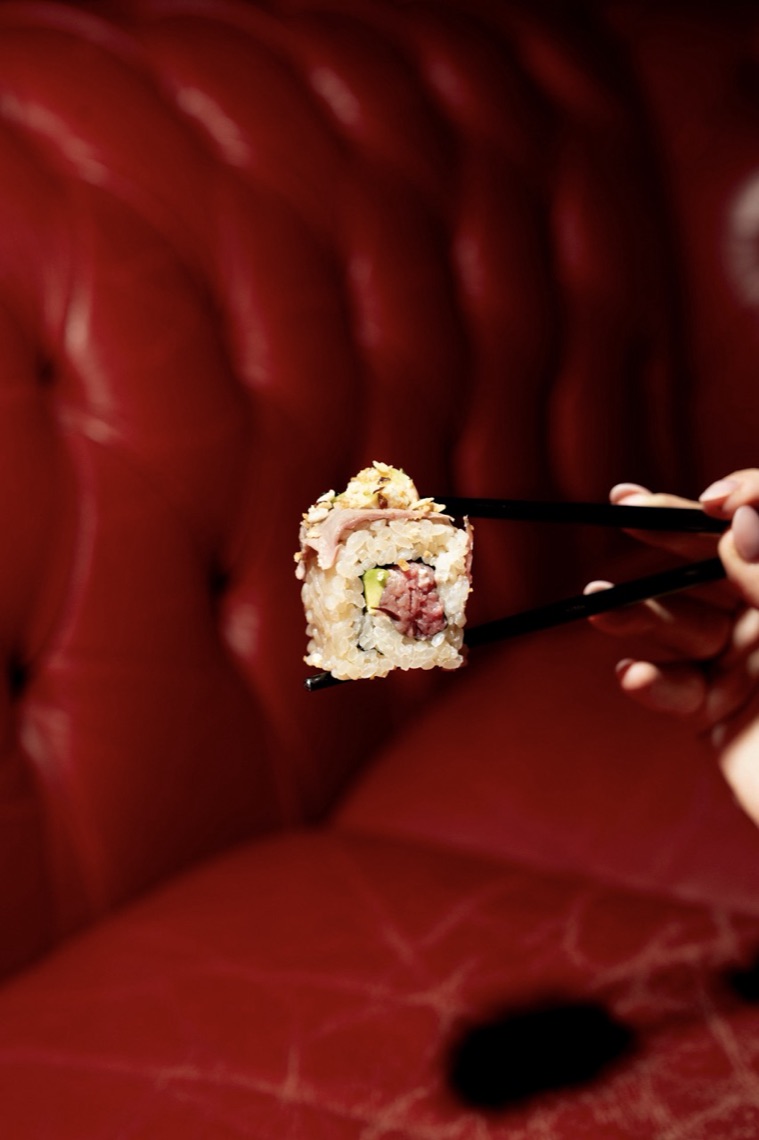 Uramaki di manzo tenuto con le bacchette